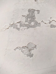 old and white concrete wall with which paint peels off.