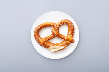 Pretzel as Oktoberfest symbol  on white ceramic plate, top view
