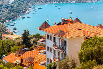 Houses and villas with red roofs in a resort town on mountain steep slope at the Mediterranean Sea....