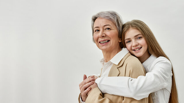 Girl Hugging Her Grandmother On White Background