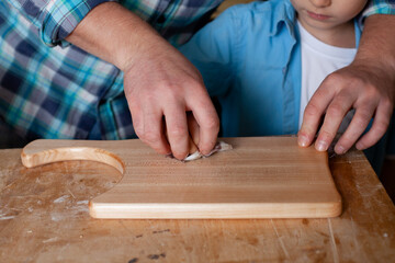 Father carpenter and son boy work in the workshop. Master dad teaches his son carpentry. Continuity of generations. Small business.