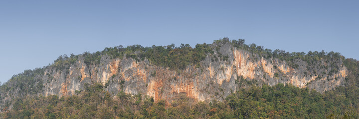 Scenic autumn landscape panorama of colorful limestone or karst mountain ridge and cliff with...