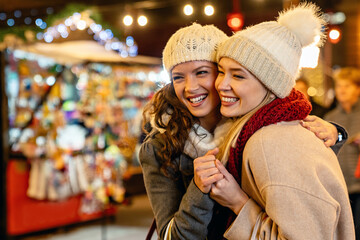 Christmas shopping people concept. Happy young women with shopping bags buying presents