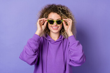 Photo of pretty cool woman wear sweatshirt arms dark eyewear smiling isolated violet color background