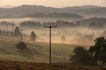 Nebel im Tal mit Strommasten