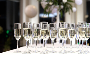 A lot of wine glasses with a champagne or white wine. . lot of glasses with champagne during on the party table. selective focus