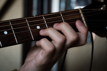 Hand playing on a guitar.