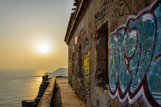 B&acirc;timent en ruine et graff&eacute;, tagu&eacute; sur fond de coucher de soleil dans une calanque pr&egrave;s de Marseille.
