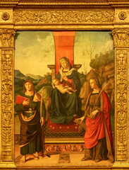 FORLÍ, ITALY - NOVEMBER 11, 2021: The paiting of Madonna with the St. John the Evangelist and St. Catherie of Alexandria in the church Basilica San Mercuriale by Marco Palmezzano (1510).