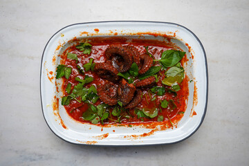 Octopus in tomato sauce with basil. Top view