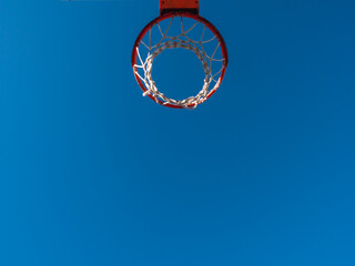 Basketball basket outside a street with blue sky, copy space for text.