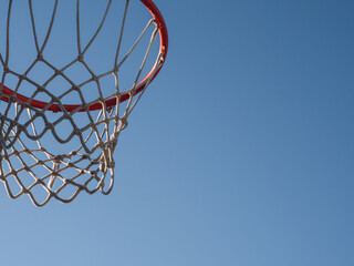 Basketball basket outside a street with blue sky, copy space for text.