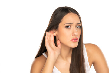 Young woman listening to something by putting hand on the ear
