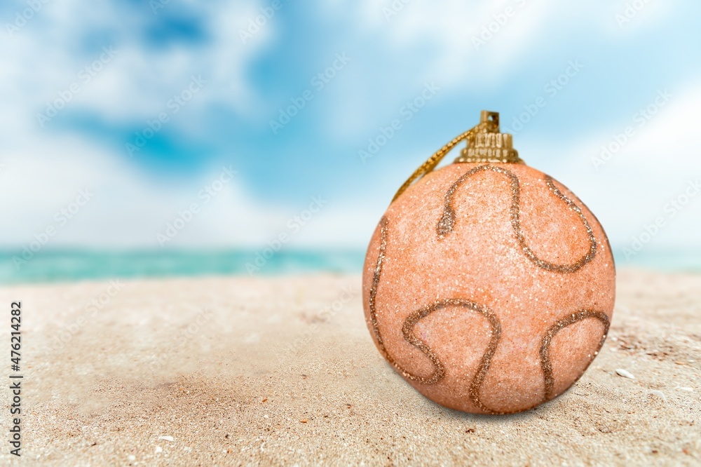 Poster Christmas toys - colored balls on the beach, blurred sea in the background. New Year or Christmas card,