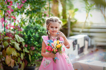 a girl in the garden in a beautiful dress and a bouquet