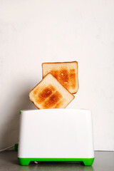 Toaster with bread slices on white background close up, space for text