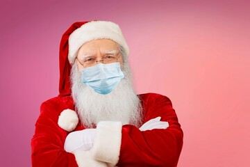 Real Santa Claus with red background, wearing face mask and glasses. Christmas with social distance. Covid-19