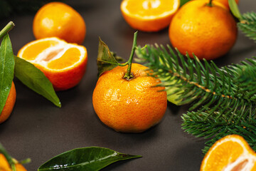 Tangerines (oranges, mandarins, clementines, citrus fruits) with leaves and fir tree branches