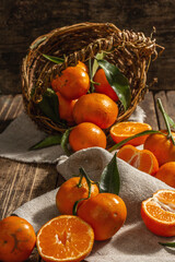 Tangerines falling out of the basket. Oranges, mandarins, clementines, citrus fruits) with leaves
