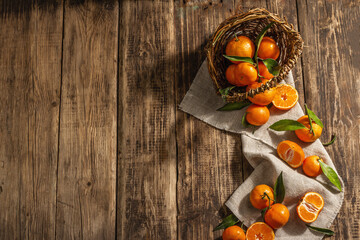 Tangerines falling out of the basket. Oranges, mandarins, clementines, citrus fruits) with leaves