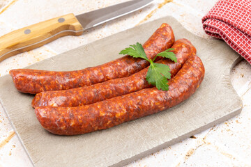 several raw merguez on a cutting board
