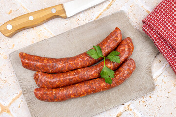 several raw merguez on a cutting board