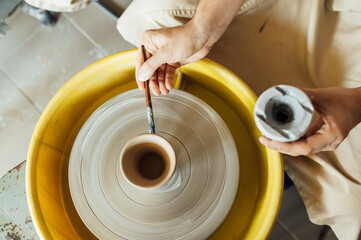 Hands of a potter. Potter making ceramic pot on the pottery wheel