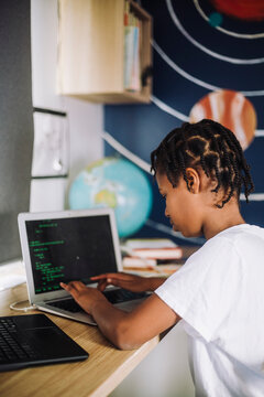 Motivated girl learning coding on laptop at home