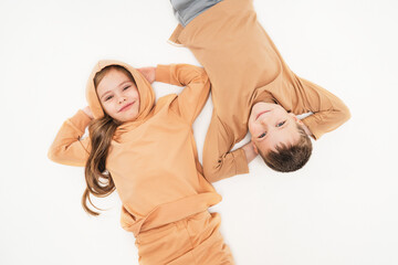 Children in sportswear lie on the floor and look into the frame. Friendship of a boy and a girl...