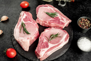 raw pork steaks on stone background