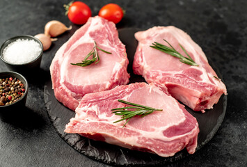 raw pork steaks on stone background