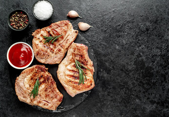 grilled pork steaks on stone background with copy space for your text