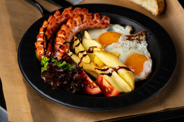 Breakfast eggs with sausage and salad french fries close up food