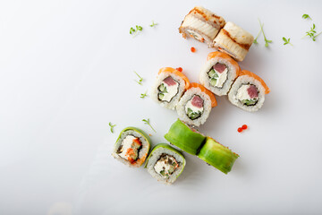 Sushi roll set with eel fish salmon and avocado on light surface