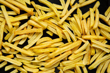 Overhead view of french fries on black background