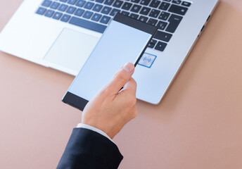 Executive hand with mobile transferring data to computer