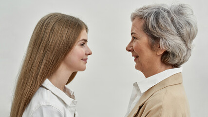 Smiling girl and grandmother looking at each other