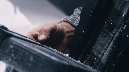 Closeup crop craftsman covered with plastic dust pressing buttons on remote control system while...