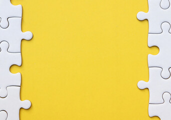 White puzzle pieces on yellow background, copy space for text.