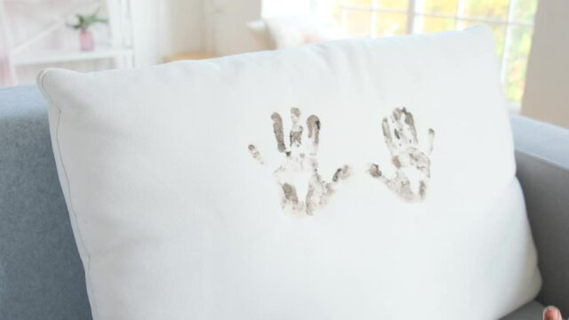 The boy runs in the apartment and stains the sofa with dirty hands.