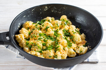 Fried cauliflower with egg and cheese with herbs