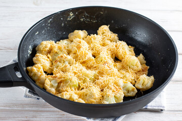 Fried cauliflower with egg and cheese with herbs