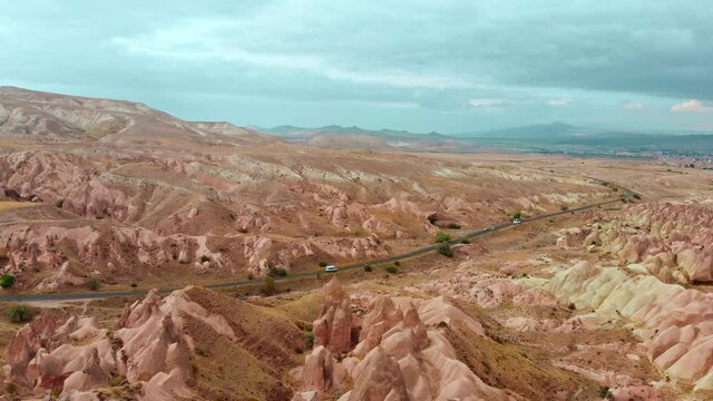 Aerial panoramic view cars buses drive on highway in cappadocia pass devrent valley fairy chimneys background .Travel and tourism in Turkey concept