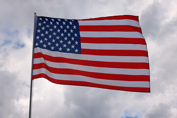 US American flag waving in stormy cloudy sky