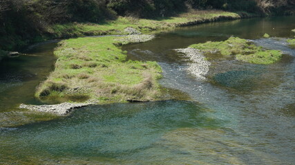 The river view with the water running over the grass land n the valley of the mountains