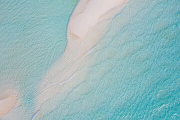 Fototapeta na wymiar Aerial view of sandbar and blue sea. Maldivian sandbank in Indian ocean, white sandy coast crystal azure color water, perfect getaway for tropical vacations. Top aerial view, calm waves, surf relax