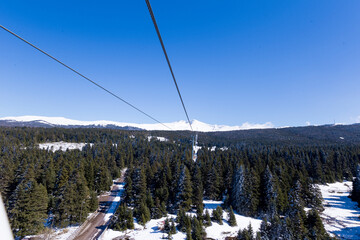 Ski slopes and Ski lifts. Small pine trees with snow. Mountain skiing and snowboarding. View of Erzurum city from Palandoken mountain