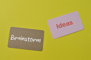 Pink card and brown card written with text IDEAS and BRAINSTORM