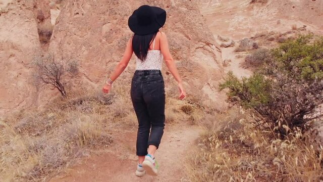 Caucasian Woman tourist enjoy freedom and travel holidays outdoors walking around fairy chimneys in devrent valley , Cappadocia