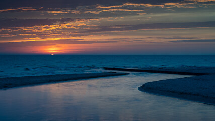 Stony Creek flows into Lake Michigan at sunset, in Benona Township Park, Shelby, Michigan.